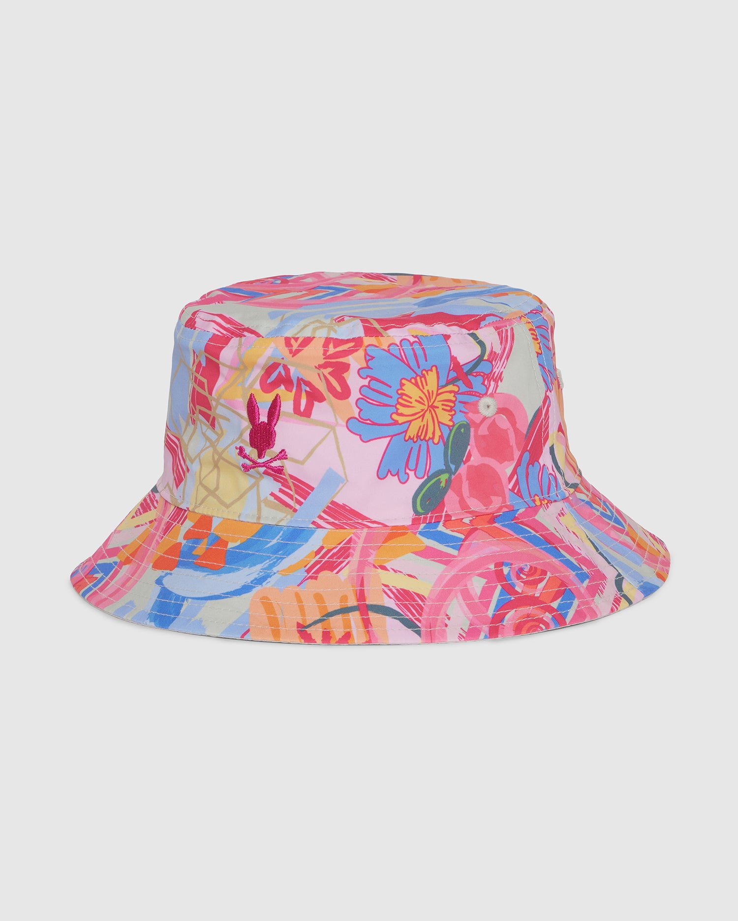 The Psycho Bunny KIDS BENTON REVERSIBLE BUCKET HAT - B0A323B2HT is a colorful accessory featuring a vibrant floral and bird print on a white background. Large flowers and parrots in shades of pink, blue, yellow, and red give it a lively, tropical appearance. This reversible bucket hat is perfect for adding a fun touch to any outfit.