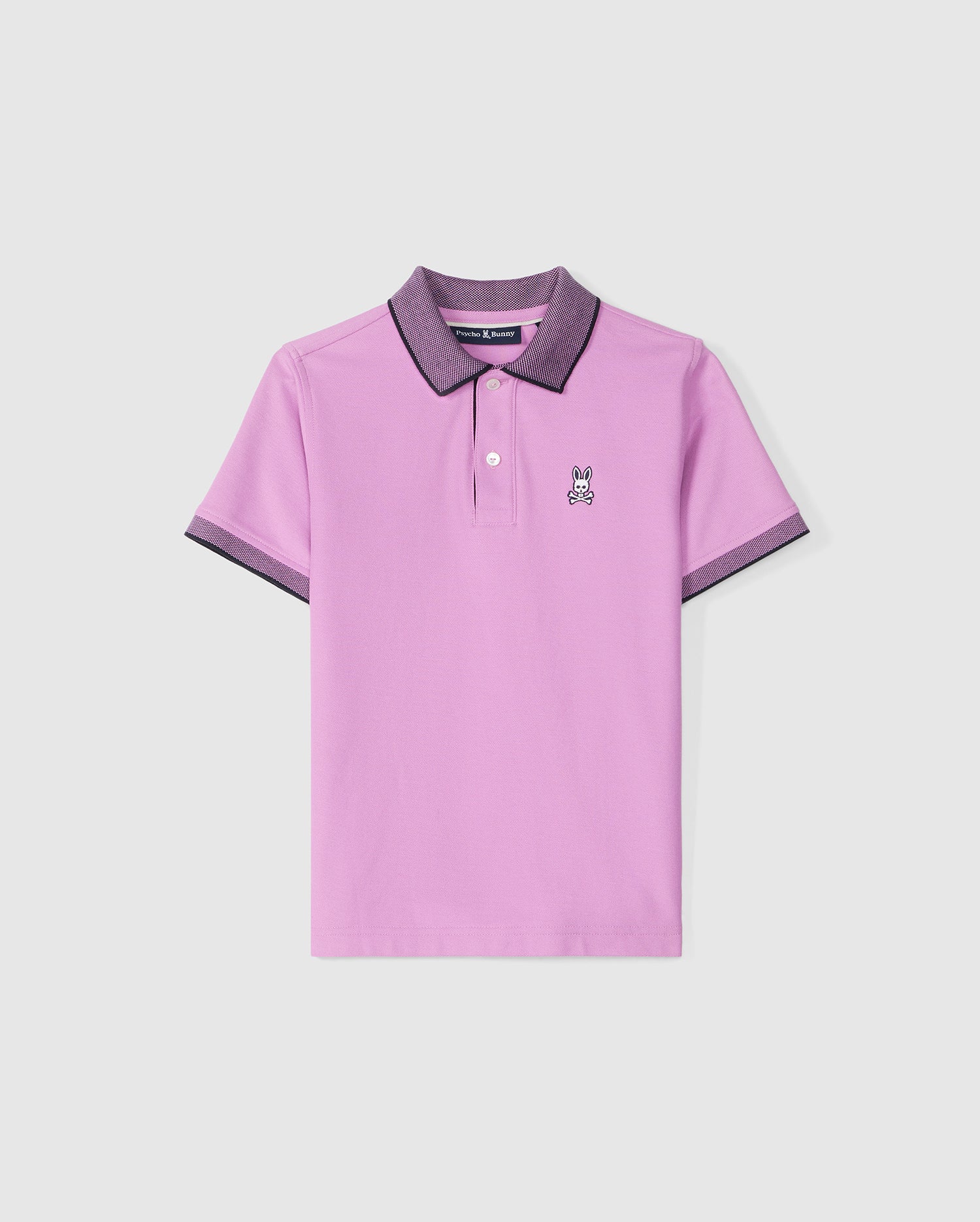 A lavender KIDS SOUTHPORT PIQUE POLO SHIRT - B0K263B200 with a dark-colored collar and sleeve edges. This Psycho Bunny kids polo features a small embroidered bunny logo on the left chest, crafted from soft Pima cotton. The shirt has a classic two-button placket and is displayed on a plain, light background.