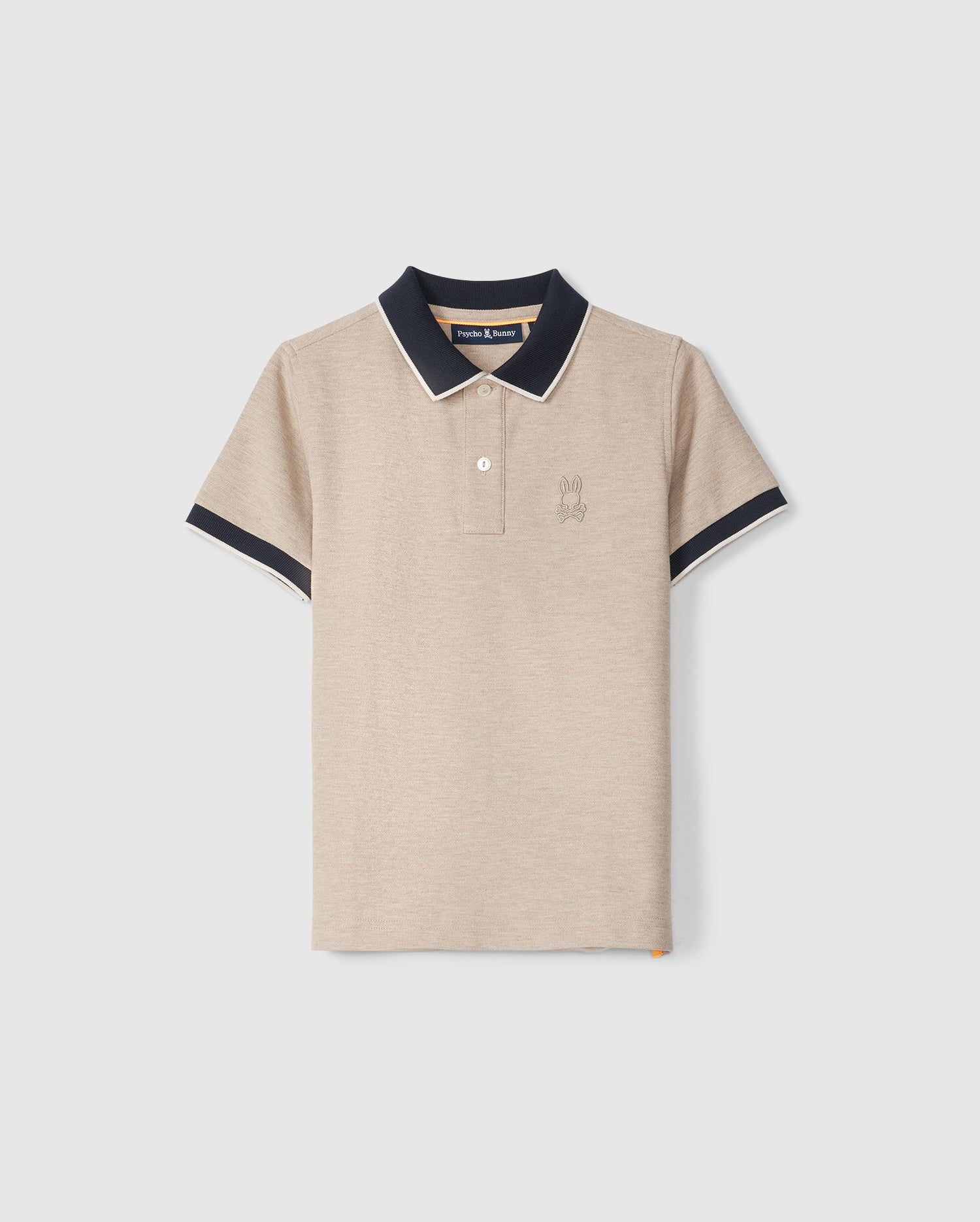 A beige short-sleeve KIDS WINDCREST PIQUE POLO SHIRT - B0K592C200 by Psycho Bunny, made of soft Pima cotton, features a navy collar and sleeve cuffs. It has a two-button placket and an embroidered emblem on the left chest. The collar and cuffs are accented with white piping for contrast. The shirt is displayed on a plain light background.