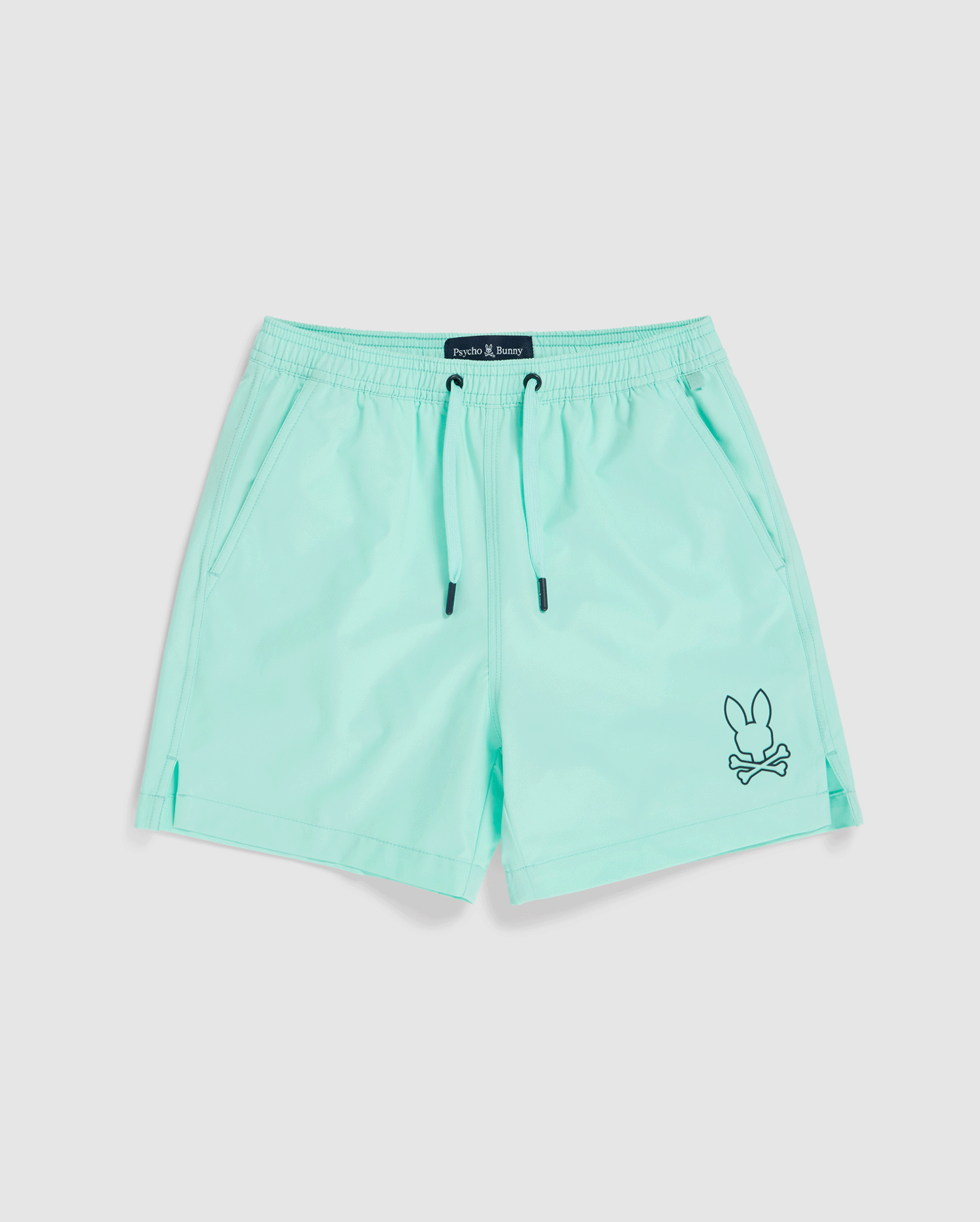 A pair of light turquoise, quick-dry KIDS PARKER HYDROCHROMIC SWIM TRUNK - B0W646C200 by Psycho Bunny with a black drawstring. The shorts feature two side pockets and a small embroidered bunny and crossbones logo in black near the bottom hem on one leg.