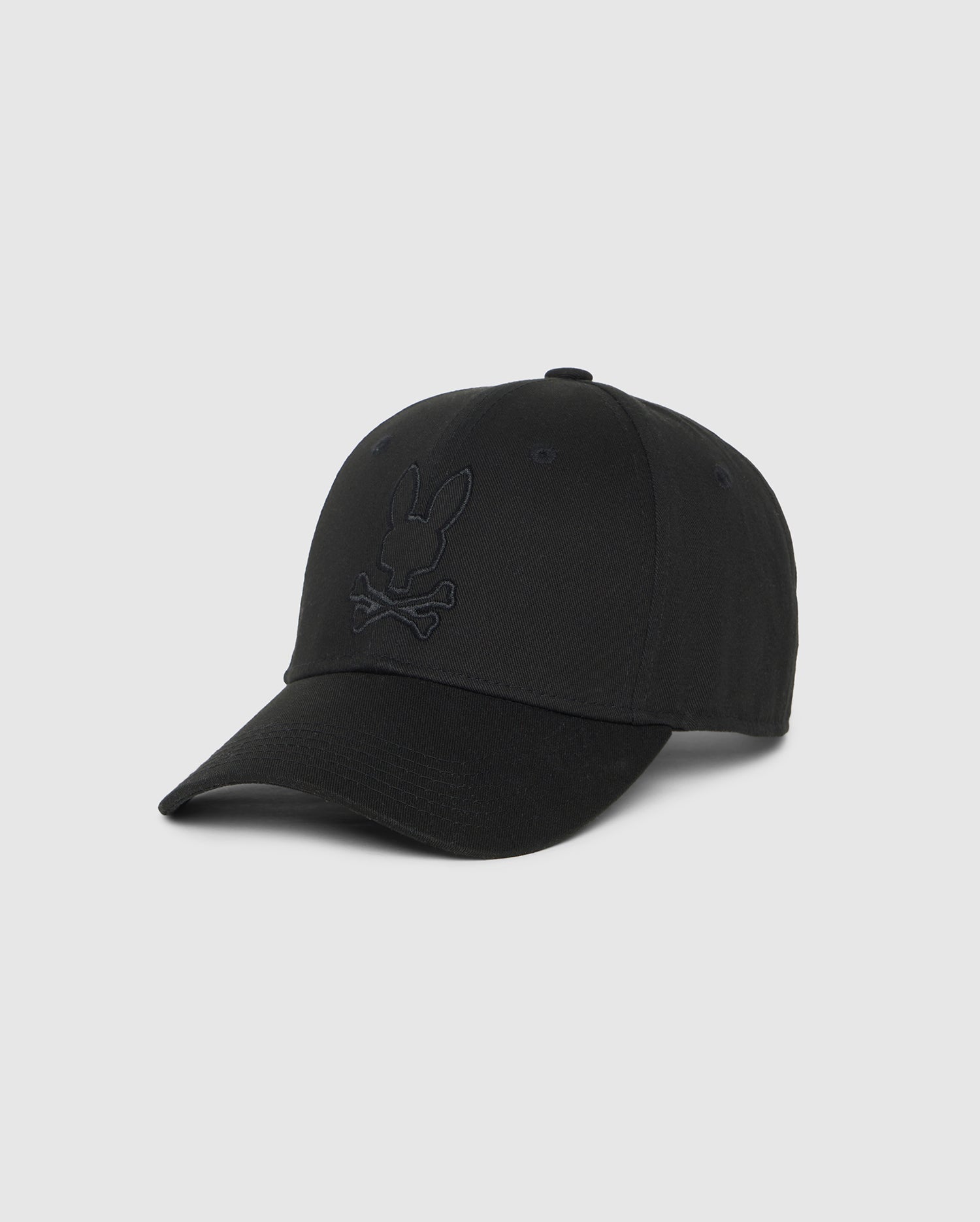 The Psycho Bunny MENS DANBY BASEBALL CAP - B6A360B2HT features a subtle embroidered Bunny head above crossbones on the front. The hat has a curved brim, an adjustable flip clasp, and a six-panel structure with eyelets on each panel.