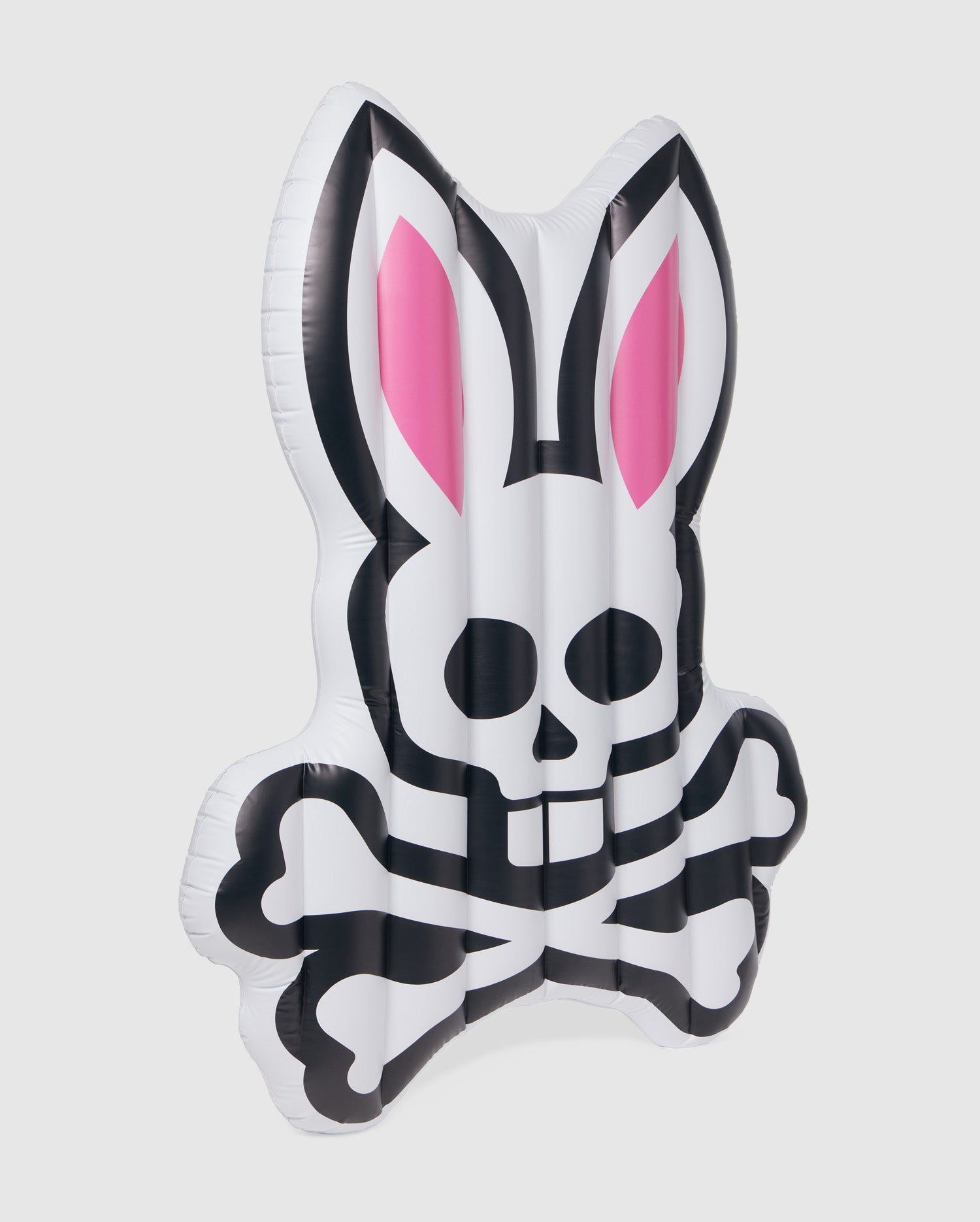 An inflatable pool floatie shaped like a bunny with a skull and crossbones design. The bunny's ears are pink inside, and the overall color is white with black and pink details. This Psycho Bunny POOL FLOATIE - B6A386B200 is perfect for your resort vacation, adding both fun and flair to your poolside relaxation.