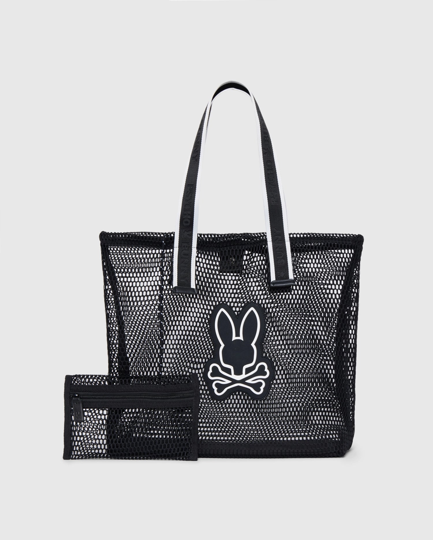 A black Psycho Bunny MENS MESH TOTE BAG - B6A388B200 with two logo-webbing straps featuring a white outline and a white emblem of a bunny head with crossbones below it on the front. Next to the mesh tote is a matching black detachable zip pouch. The background is plain white.