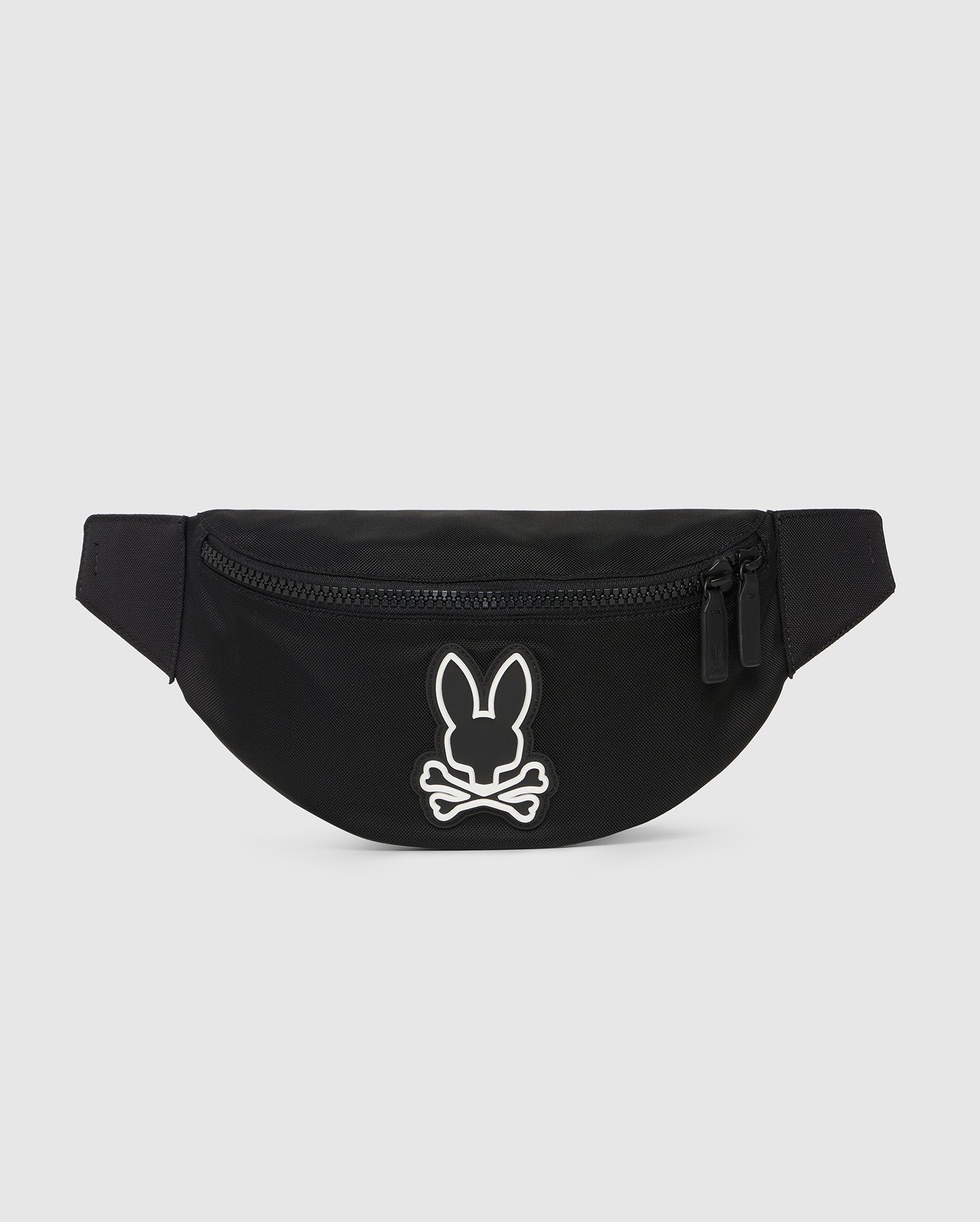 A black canvas Psycho Bunny hip bag with a white bunny logo embroidered on the front, featuring a main zippered compartment and an adjustable strap. The background is plain white.