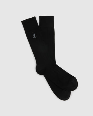 This product is the MENS DRESS SOCK - B6F154E200 by Psycho Bunny, offering a pair of black knee-high socks made from high-quality Peruvian Pima cotton and embellished with a small, stylized rabbit emblem set against a light gray backdrop.