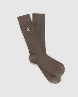 A pair of MENS DRESS SOCK - B6F154E200 by Psycho Bunny, crafted from Peruvian Pima cotton in a long, dark green ribbed design, features a small embroidered bunny logo near the top. These premium quality dress socks are neatly displayed parallel against a light gray background.