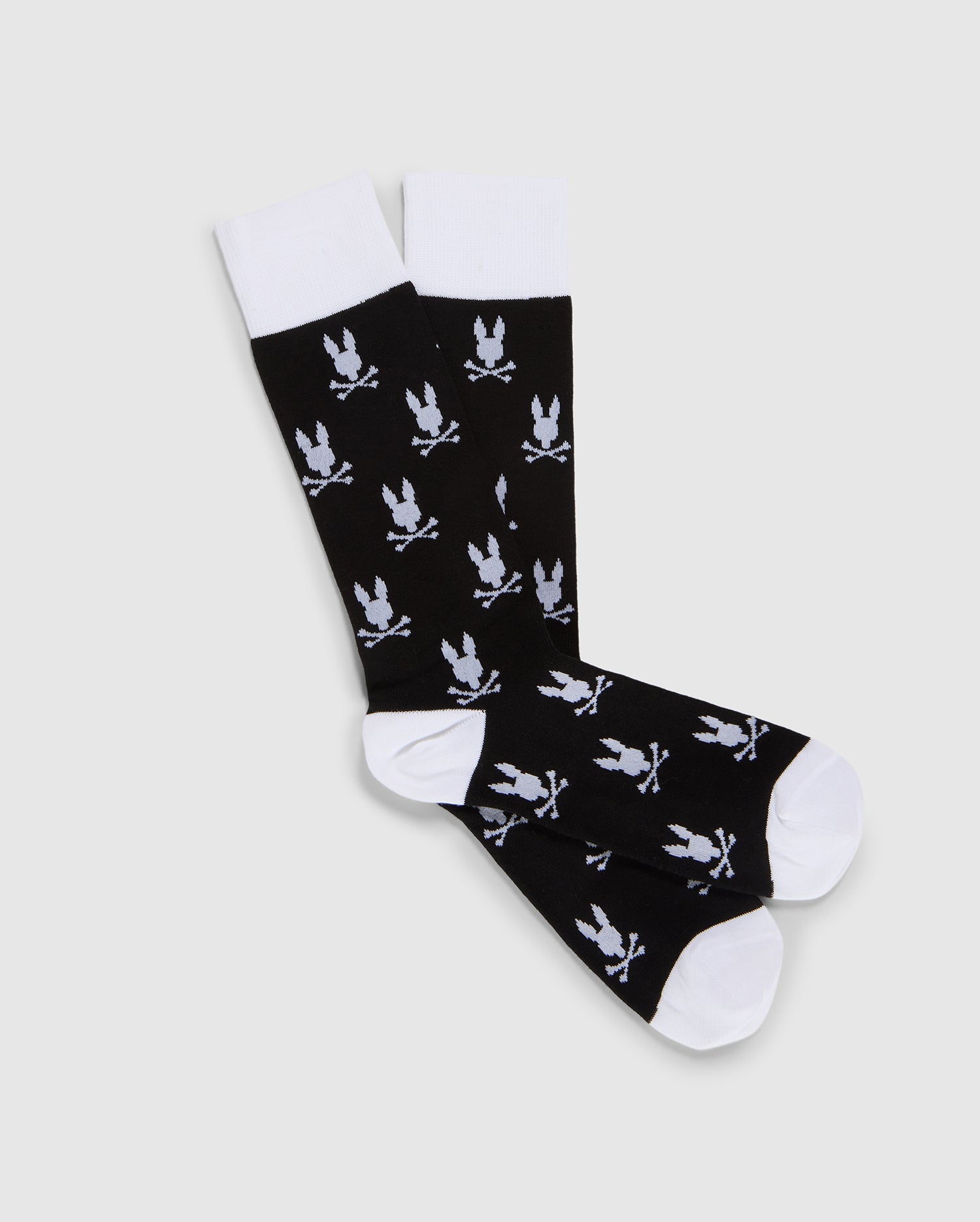 A pair of Psycho Bunny black dress socks with a pattern of white flying doves, displayed on a flat, neutral background.