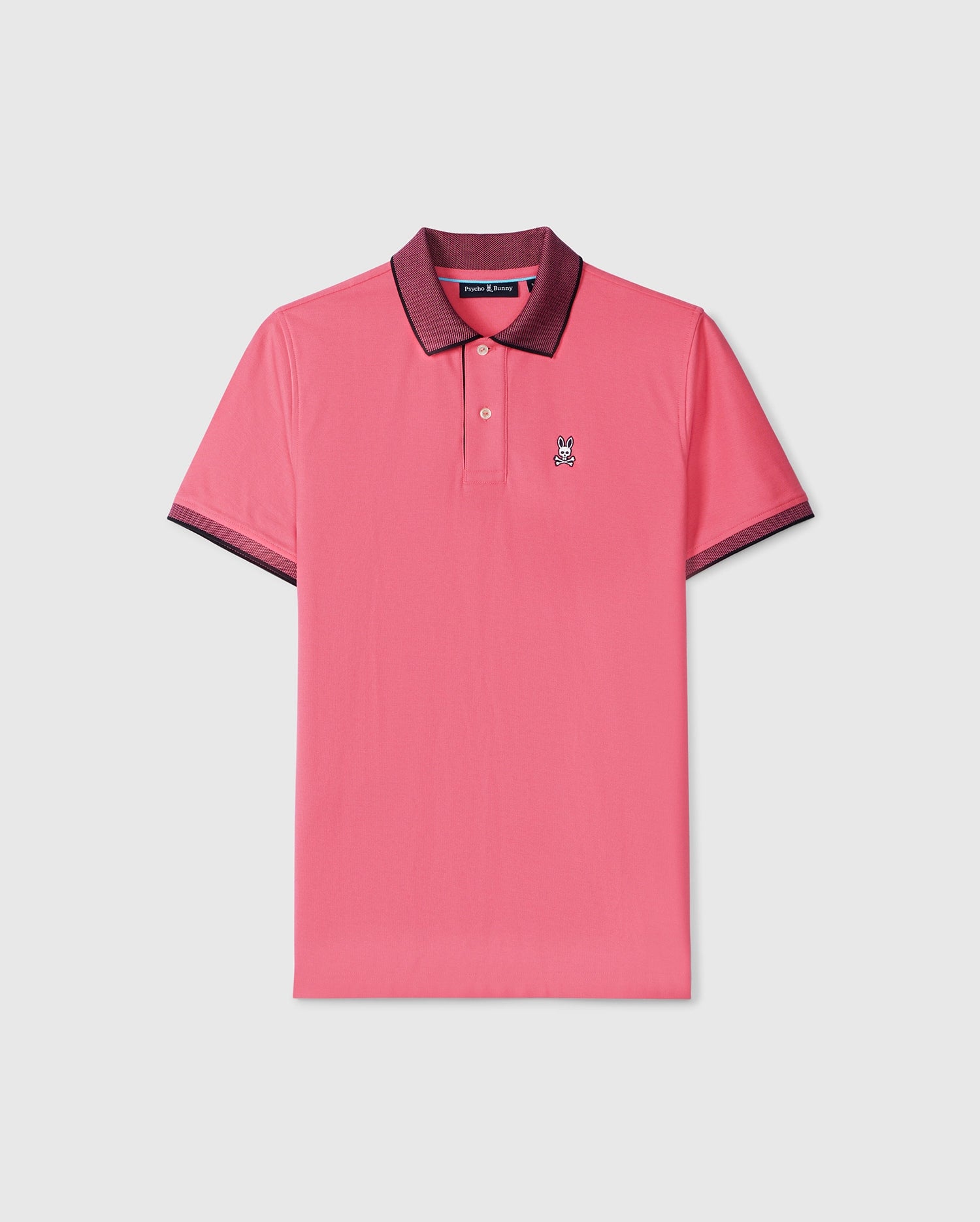 Men's Psycho Bunny pink polo shirt with black trim on the collar and sleeves, featuring a small embroidered logo on the left chest, crafted from Pima cotton piqué, displayed on a plain white background.
