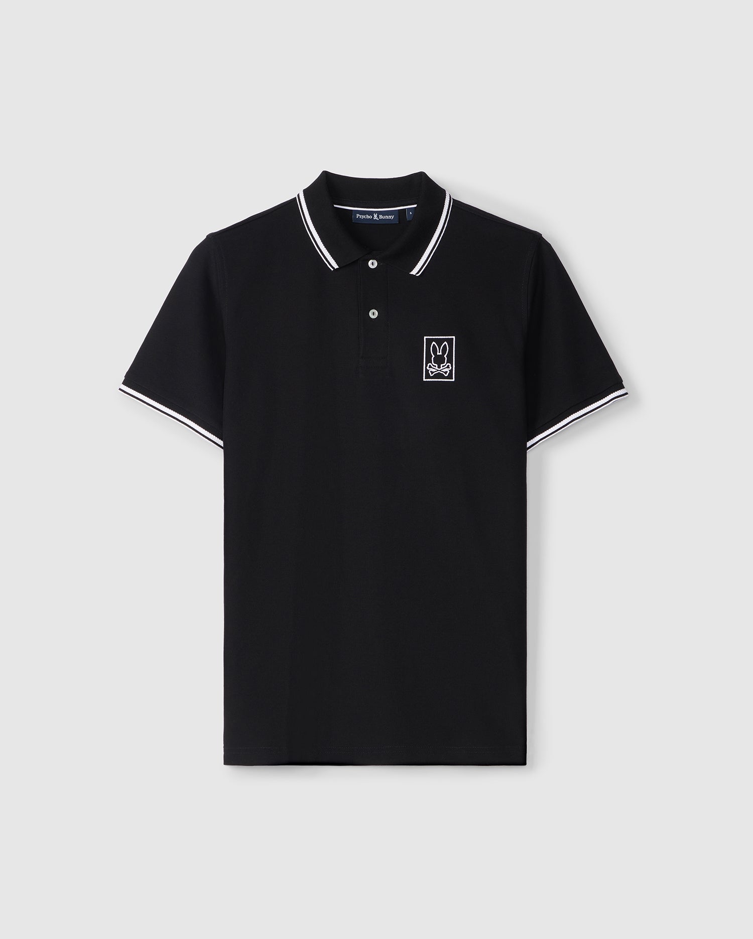 A black Psycho Bunny polo shirt with contrasting white crease-resistant collar and sleeve trim, featuring a small white embroidered logo on the left chest area. The shirt is displayed on a plain background.