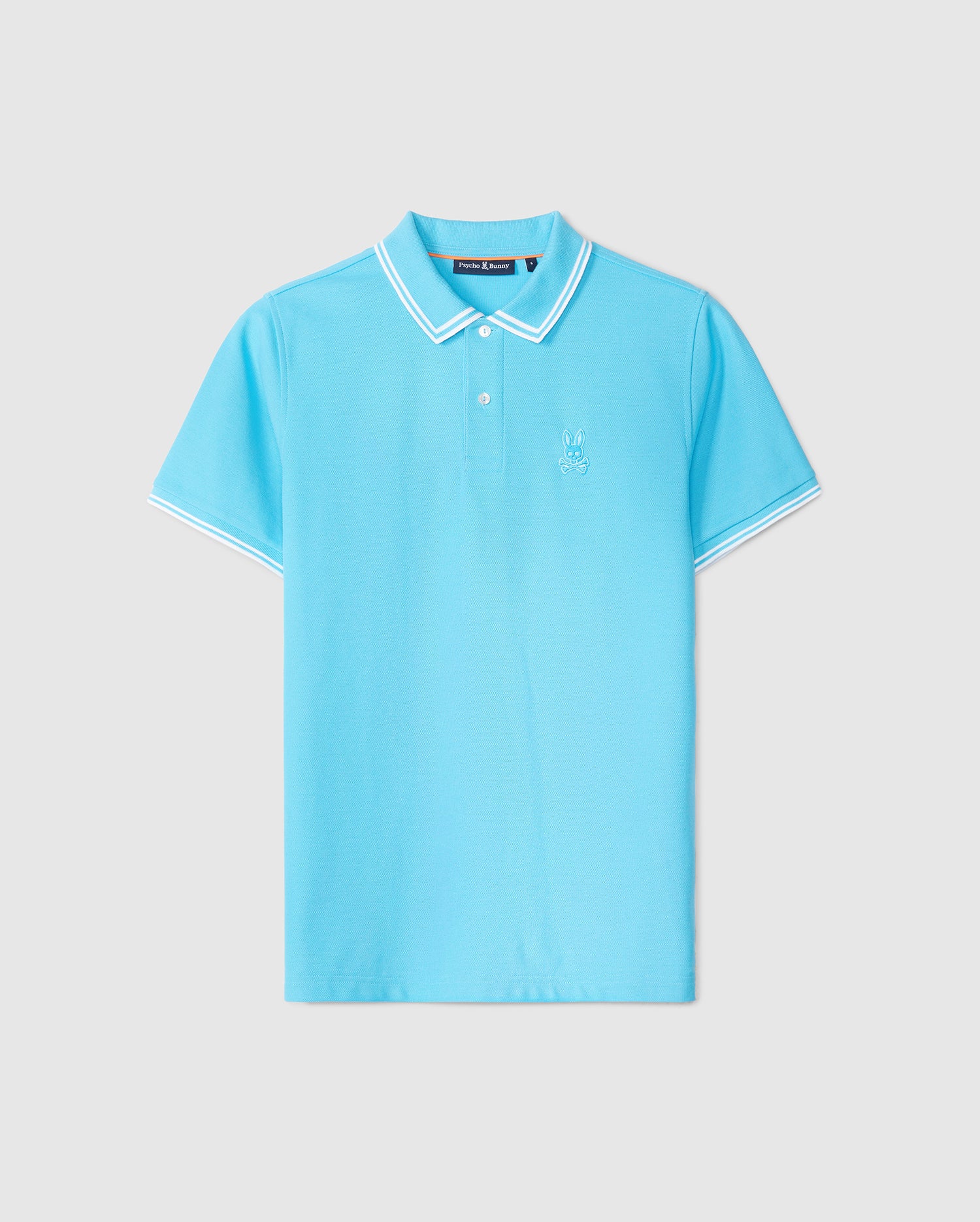 A light blue short-sleeved Psycho Bunny MENS BELTON PIQUE POLO - B6K575C200 with white trim on the collar and sleeve cuffs. Made from luxurious Pima cotton, the shirt features a small embroidered Bunny logo on the left side of the chest. It is displayed against a plain light grey background.
