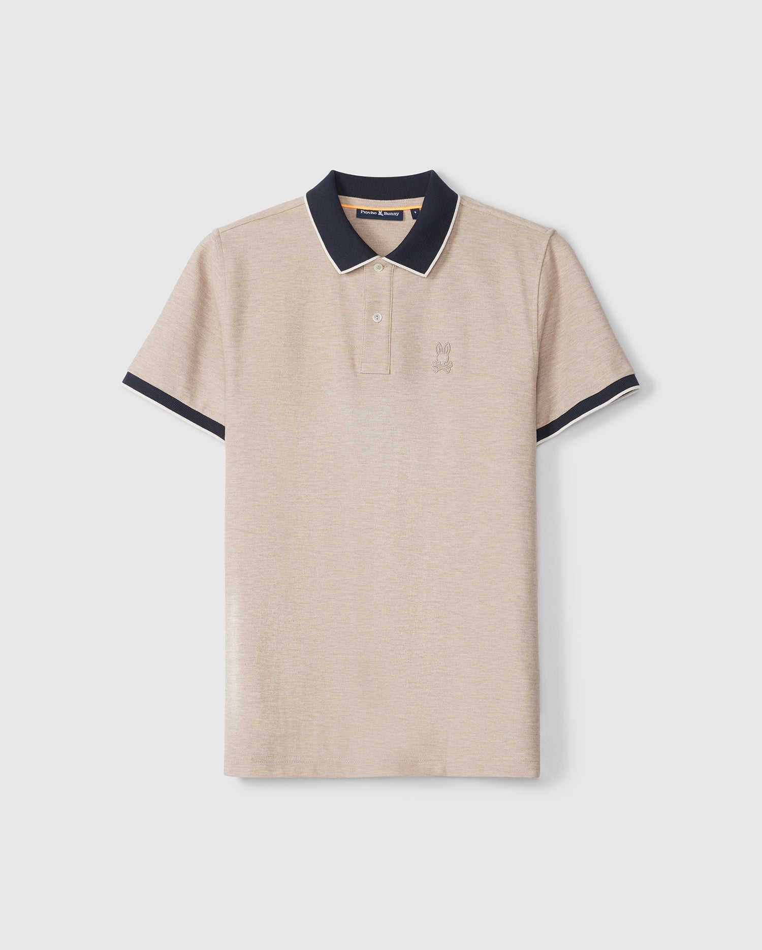 A beige Psycho Bunny pique polo shirt with navy blue trim on the collar and sleeves, displayed against a plain background. The shirt features a small embroidered logo on the left chest.
