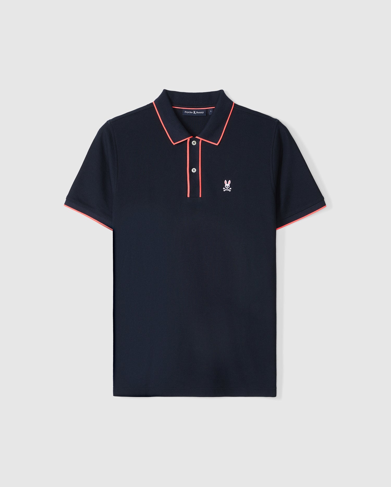 A navy blue Pima cotton polo shirt with red and white trim on the collar and sleeves. The shirt features two genuine mother of pearl buttons and an embroidered Bunny logo on the left chest. Introducing the Psycho Bunny MENS DALLAS PIQUE POLO SHIRT - B6K602C200.
