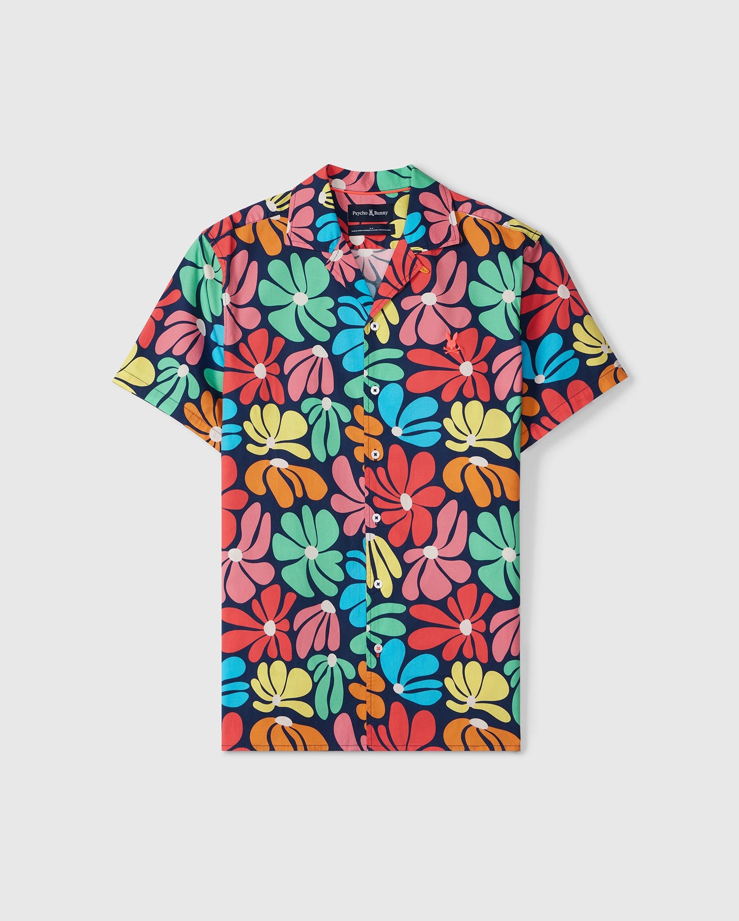 A short-sleeved button-up floral print shirt with a vibrant, colorful pattern featuring large, overlapping flowers in shades of red, yellow, green, and blue on a dark background. This sun-soaked statement piece includes a collar and front pocket. Ideal for pairing with its matching set. The product is the Psycho Bunny MENS MENTZ ALL OVER PRINT SHIRT - B6Q396B200.