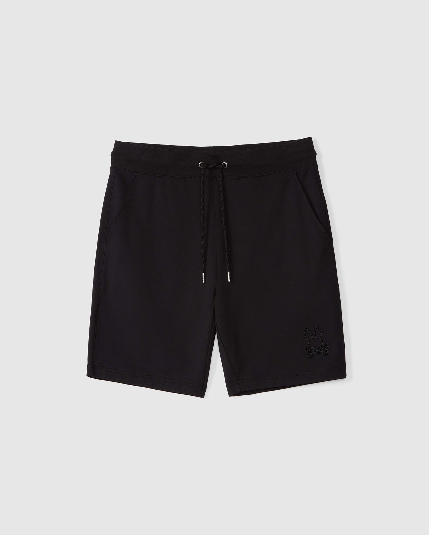 A pair of black athletic shorts crafted from micro French terry for ultimate comfort, featuring an elastic waistband and a drawstring closure. The MENS LIVINGSTON SWEATSHORT - B6R408B200 by Psycho Bunny has side pockets and showcases a small embroidered logo of a bunny on the bottom left leg. The background is a plain light grey.