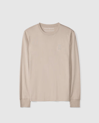 The Psycho Bunny MENS ALBERTON LONG SLEEVE TEE - B6T867D200 is a beige, long-sleeve shirt made from soft Pima cotton. It features a subtle embroidered rabbit head logo on the left chest set against a plain white background.