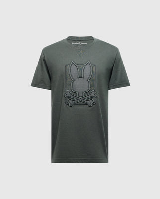 The Men's Pierce Embroidered Graphic Tee (B6U115E200) by Psycho Bunny in dark green features a stylized graphic of a rabbit face above two crossed bones. Made from soft Pima cotton, this design is prominently displayed on the chest, with the Psycho Bunny brand name visible inside the neckline.