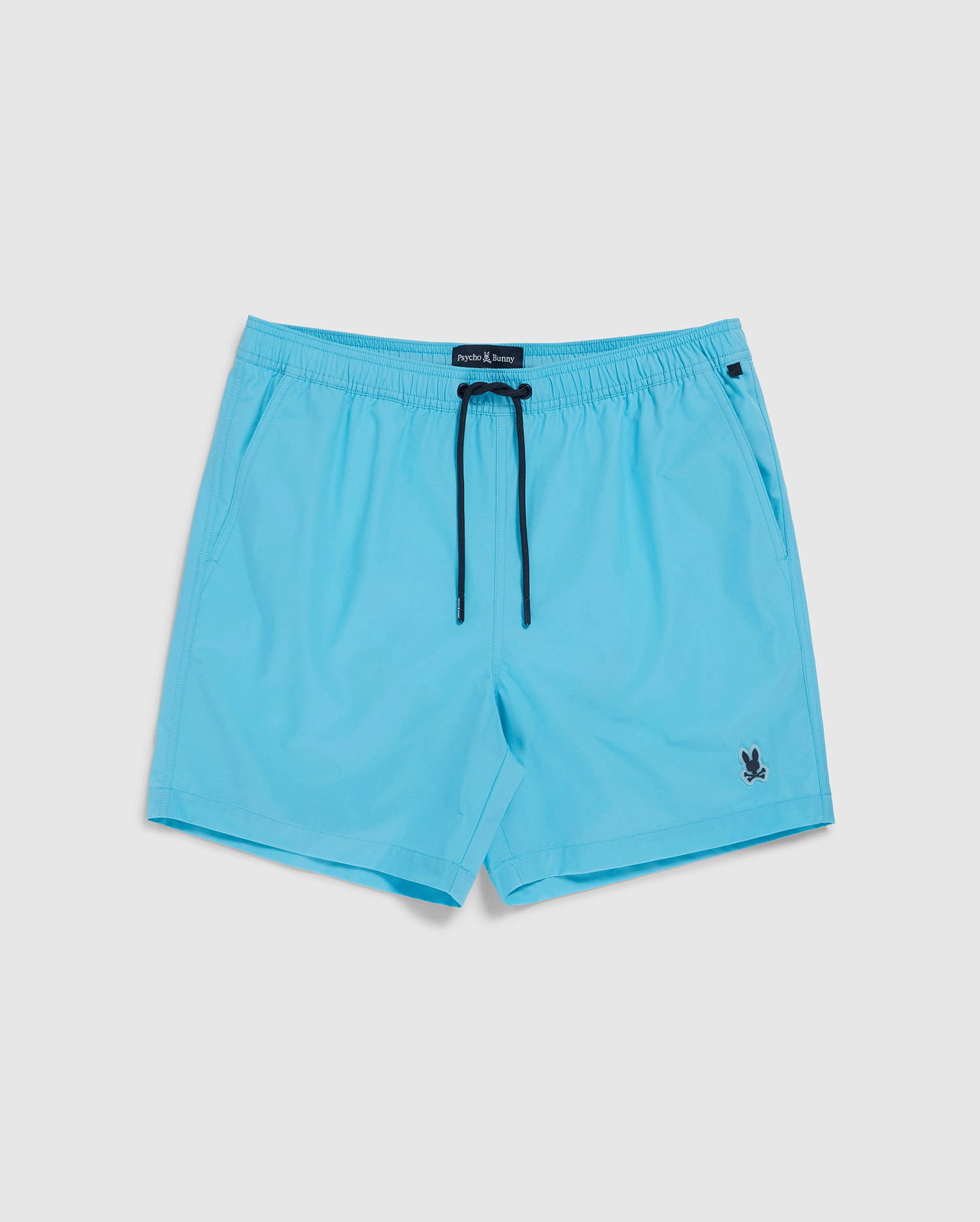 Light blue Psycho Bunny hydrochromic swim shorts with a dark blue drawstring and a small black logo on the lower left leg, displayed against a plain white background.