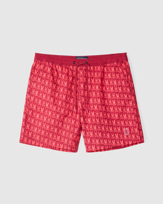 The Psycho Bunny MENS TILDEN PRINT SWIM TRUNK - B6W729D200 is a pair of red swim trunks featuring a subtle pattern of small, crown-like shapes. The waistband is a slightly darker shade of red and includes a drawstring for an adjustable fit. These quick-dry swim trunks also come with a small logo near the bottom hem.